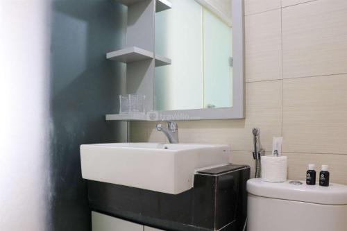 Un baño con un lavabo blanco y un inodoro. en Spacious 3BR with Good View at Gateway Pasteur Apartment By Travelio, en Bandung