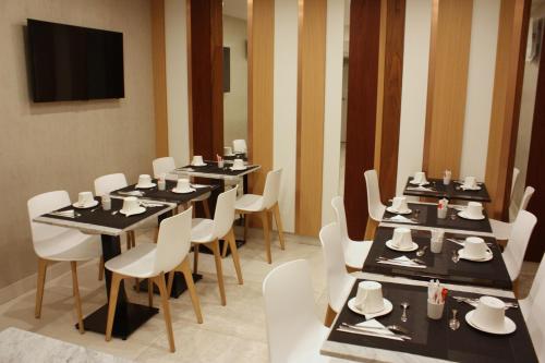 a dining room with tables and chairs and a television at Le Malown in Paris