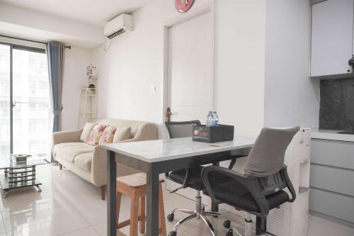 a kitchen and living room with a table and chairs at Restful and Modern 3BR at Daan Mogot City Apartment By Travelio in Jakarta