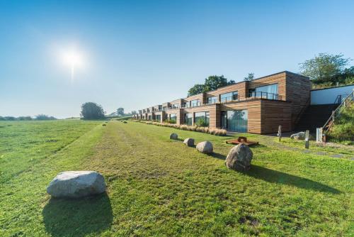 a house on a field with rocks in the grass at Panorama Hotel Aschberg in Ascheffel