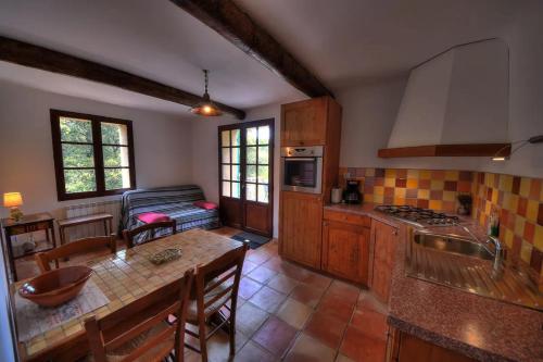 - une cuisine avec une table et un canapé dans une chambre dans l'établissement Le RAVAS, à Aups