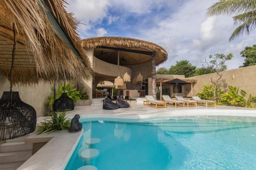 a swimming pool with chairs and a house at Karma Resort in Bophut 