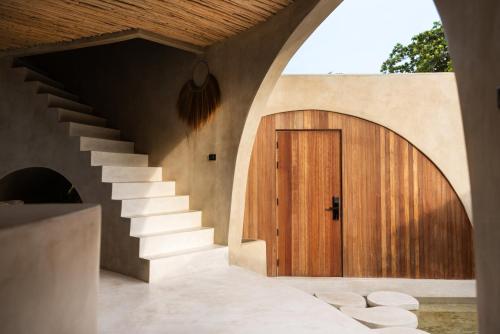 a house with a wooden door and stairs at Karma Resort in Bophut 
