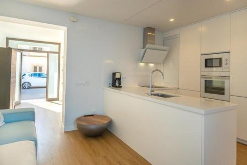 a white kitchen with a sink and a counter at Schönes mediterranes Haus in der Nähe des Meeres in Cala Morlanda in S'Illot