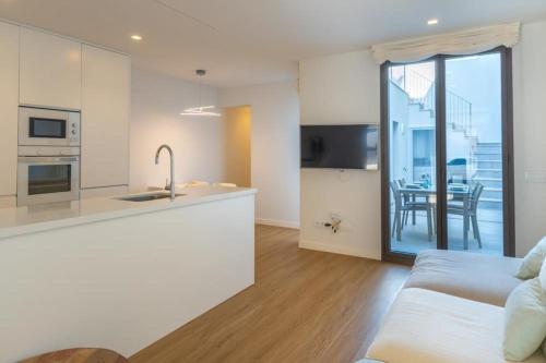a kitchen and a living room with a couch at Schönes mediterranes Haus in der Nähe des Meeres in Cala Morlanda in S'Illot