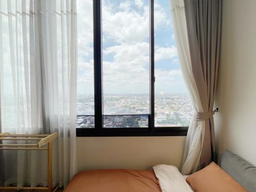 a room with a bed and a large window at 2514 BTS OnNut Siamese 87 Two bedroom apartment in Bangkok