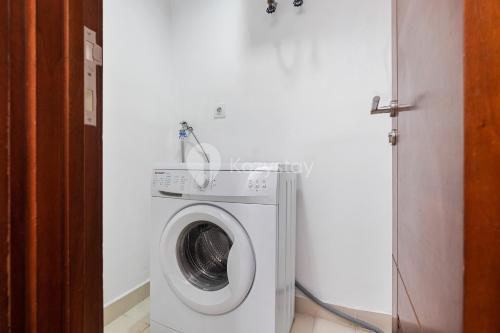 a washer and dryer in a white room at Sattva by Kozystay - Kuningan in Jakarta