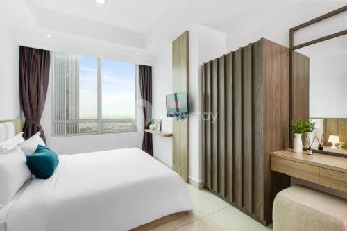 a bedroom with a white bed and a large window at Sattva by Kozystay - Kuningan in Jakarta