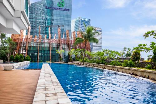 a swimming pool in a city with tall buildings at Sattva by Kozystay - Kuningan in Jakarta