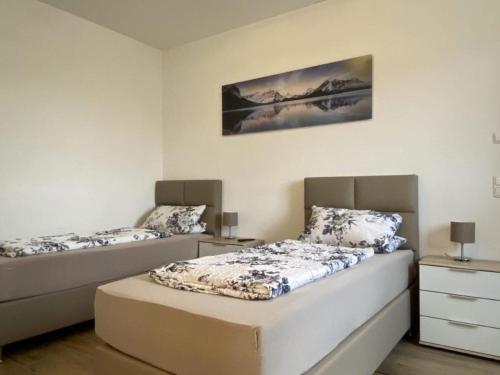 a bedroom with two beds and a painting on the wall at Ferienwohnung in Heselbach mit Grill, Whirlpool und Garten in Wackersdorf
