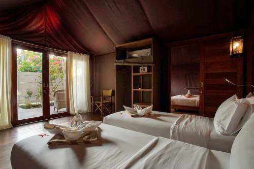 a bedroom with two beds and a window at Gili Tenda in Gili Trawangan
