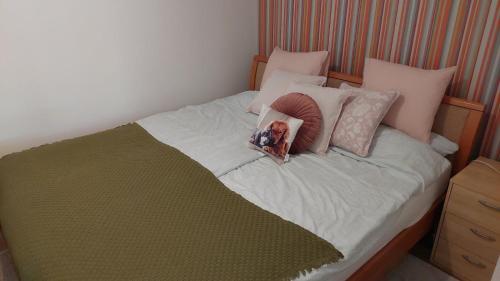 a dog laying on top of a bed with pillows at Dizike Pet-friendly Guesthouse in Budapest