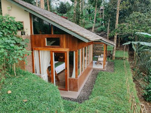 a small house with a glass door in a forest at The Lookout Cabin in Pupuan Tabanan Bali in Tabanan