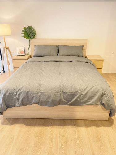 a bedroom with a large bed with a wooden frame at 2514 BTS OnNut Siamese 87 Two bedroom apartment in Bangkok