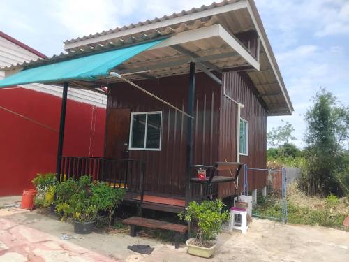 a red tiny house with a blue awning at ร่มเย็น in Ban Na Klang