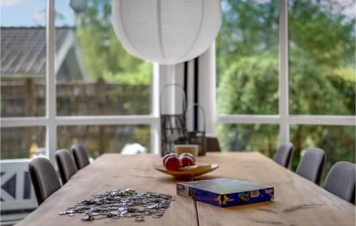 a wooden table with a bowl of fruit on it with windows at Beautiful Home In Græsted With Wifi in Græsted