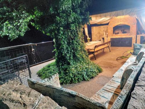 a large tree in the middle of a patio with a bench at Vikendica Drinski mir in Loznica