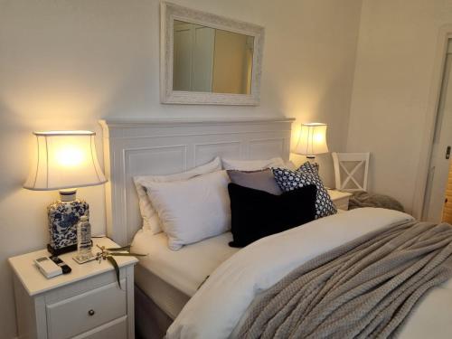 a bedroom with a bed with pillows and two lamps at Winemakers Cottage at Treetops Red Hill in Red Hill