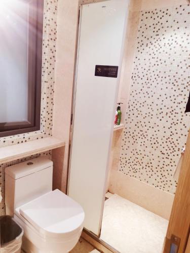 a bathroom with a toilet and a shower at Shenzhen Binhe Impression Hotel Apartments in Shenzhen