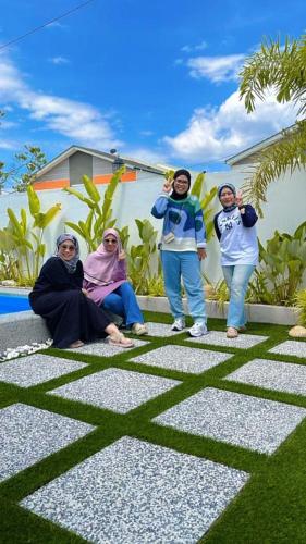 a group of women posing for a picture on the grass at SP Homestay Puncak Alam in Bandar Puncak Alam
