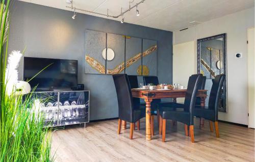 a dining room with a wooden table and black chairs at Awesome Home In Vlagtwedde in Vlagtwedde