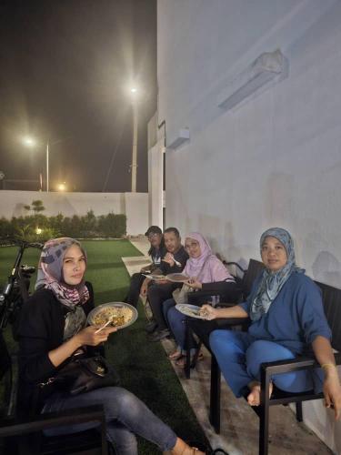 a group of people sitting in chairs eating food at SP Homestay Puncak Alam in Bandar Puncak Alam