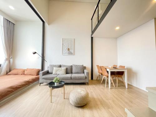 a living room with a couch and a table at 2514 BTS OnNut Siamese 87 Two bedroom apartment in Bangkok