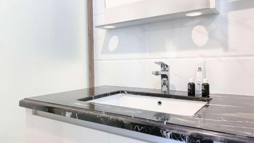 a bathroom counter with a sink and a mirror at Comfort Stay 2BR at Sky House BSD Apartment By Travelio in Tangerang