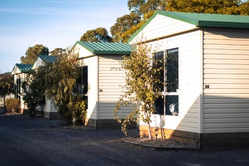 a small white house with a green roof at Strahan Beach Tourist Park in Strahan