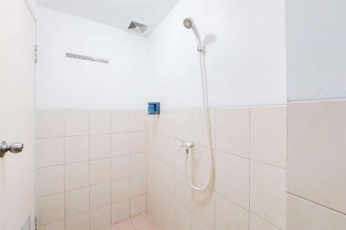 タンゲランにあるWell Furnished with Cozy Designed Studio Urbantown Serpong Apartment By Travelioの白いタイル張りのバスルーム(シャワー付)