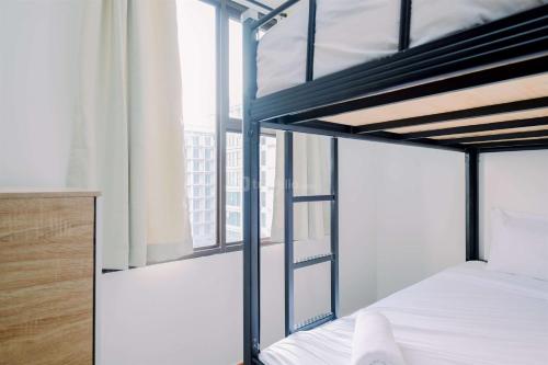 a bedroom with two bunk beds and a window at Best Deal and Comfort Designed 2BR Transpark Cibubur Apartment By Travelio in Depok