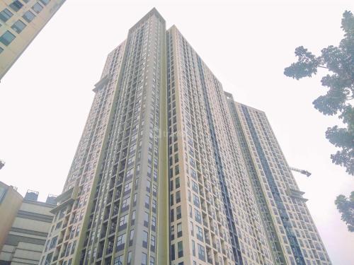 a tall white building with many windows at Best Deal and Comfort Designed 2BR Transpark Cibubur Apartment By Travelio in Depok