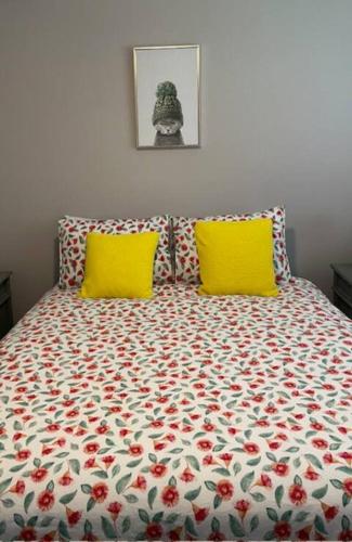 a bed with two yellow pillows in a bedroom at Huckleberry House Stanthorpe in Stanthorpe