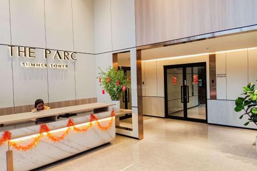 a woman is sitting in the lobby of aenna house at Good Deal Studio at The Parc South City Apartment By Travelio in Tangerang