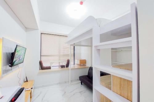 a white living room with a couch and a tv at Good Deal Studio at The Parc South City Apartment By Travelio in Tangerang