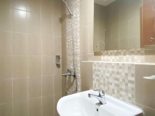 チカランにあるComfort Living Studio at Enviro Apartment By Travelioの洗面台とシャワー付きのバスルーム