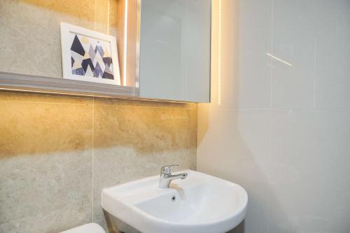 a bathroom with a sink and a toilet at Warm and Minimalist Studio Transpark Bintaro Apartment By Travelio in Tangerang