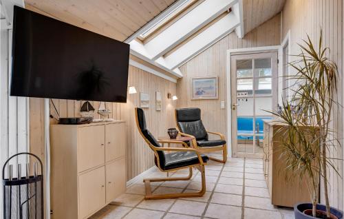 a living room with two chairs and a flat screen tv at Holiday Home Gøgevej Dronningmølle Xi in Dronningmølle