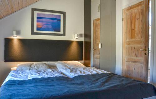 a bedroom with a bed with a blue blanket at Holiday Home Gøgevej Dronningmølle Xi in Dronningmølle