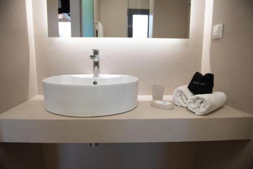 a white sink in a bathroom with a mirror at Raptis Aparthotel Sivota in Sivota