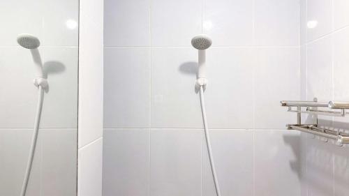 a bathroom with two shower heads on the wall at Fully Furnished with Cozy Design Studio Tokyo Riverside PIK 2 Apartment By Travelio in Rawalembang