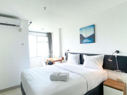 芝卡朗Restful and Comfy Studio Enviro Apartment By Travelio的酒店客房带一张大床,带白色床单