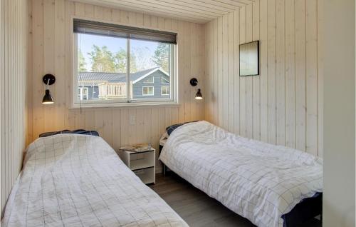 two beds in a room with a window at Seven-Bedroom Holiday Home In Frederiksvark in Frederiksværk