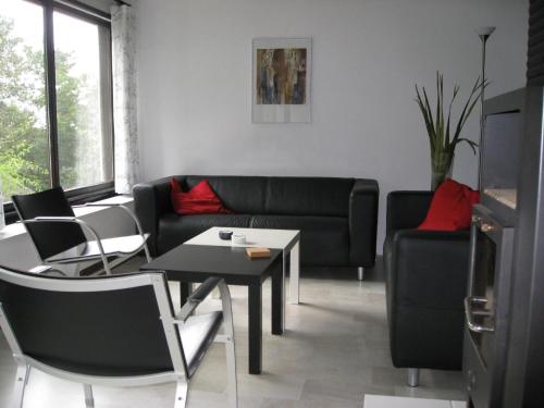 a living room with a couch and a table and chairs at Am Sternberg 36 in Frankenau