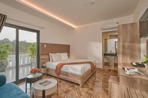 a bedroom with a bed and a living room at California Hotel in Da Lat