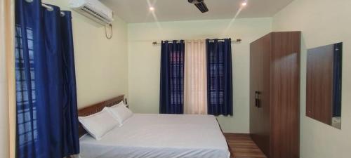 a bedroom with a bed with blue drapes at Texas Heritage Guest house 4 Bedrooms in Trivandrum