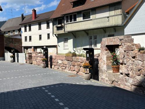 a building with a stone wall next to a street at Hotel Rössle in Alpirsbach