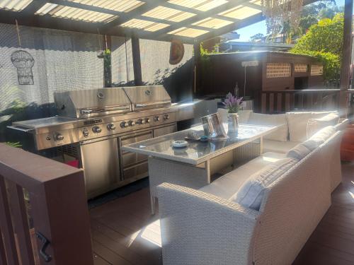 an outdoor patio with a grill and a table and chairs at Wellness Stay in Private Home near beaches, rainforest and South Coast, 2 rooms booked separately in Dapto