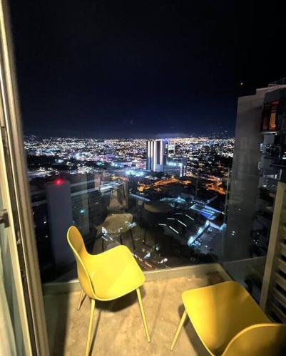 a room with two chairs and a view of a city at Studio Sabana Secrt 3011 in San José