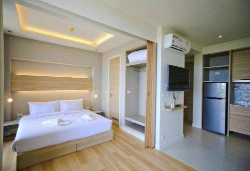 a bedroom with a large white bed and a television at Stunning sea view apartment with pool in Ao Nang Beach